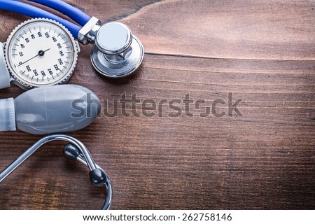 organized copyspace blood pressure monitor stethoscope on vintage wooden board medical concept