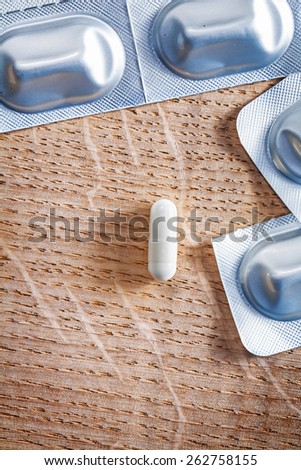 pils with blister pack on vintage wooden board medical concept