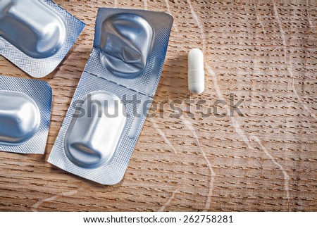 blister pack with pills on wooden board medical concept