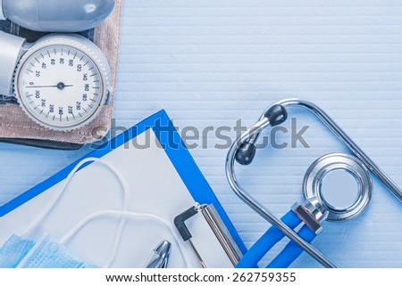 blood pressure monitor clipboard with blank sheet of paper stethoscope medical concept