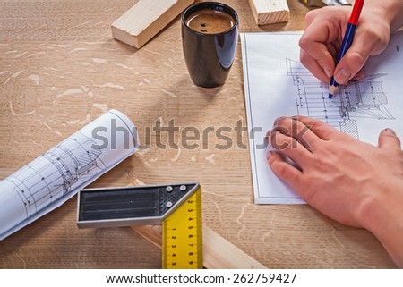 hans of carpenter on table with blueprint and coffee in cup construction concept
