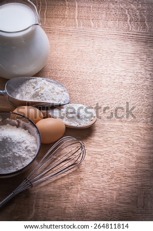 organized copyspace flour in spoon bowl and scoop eggs corolla pitcher with milk on wooden board food and drink still life