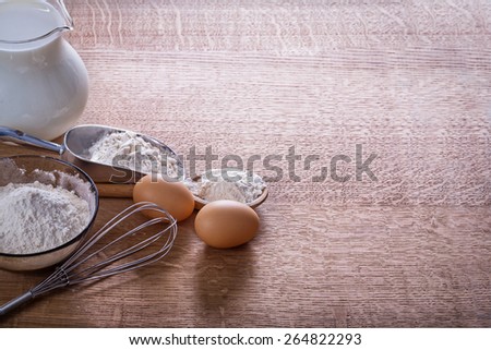 organized copyspace eggs flour in spoon scoop bowl pitcher milk on wooden board food and drink concept