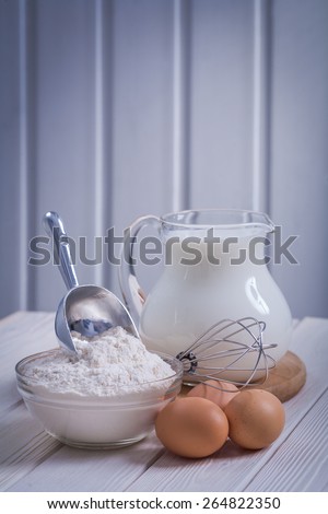 flour in bowl scoop egs jug with milk on white painted old wooden board food and drink concept