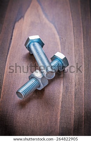bolts and nut on vintage wooden board construction concept