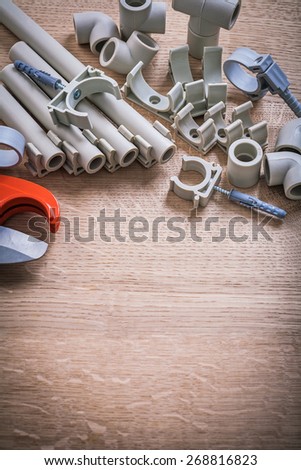 Vertical Version Big Set Polypropylene Fixators And  Pipes With Clips Pipe Cutter On Wooden Board