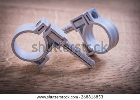 Two Polypropylene Pipe Fixators On Wooden Board