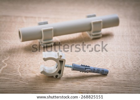 Pipe  With Clips And Polypropylene Fixator On Wooden Board