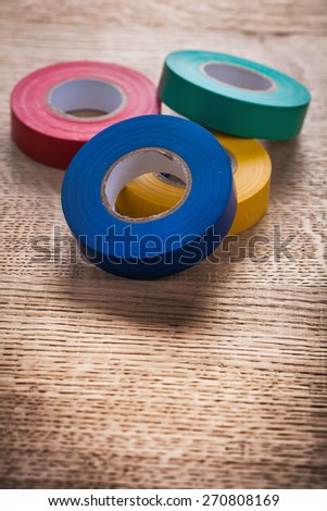 four rolls of insulating tape on wooden board construction concept