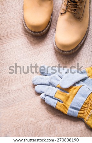 working boots and protective gloves on wooden board construction concept