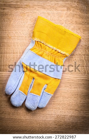 protective work glove on wooden board construction concept