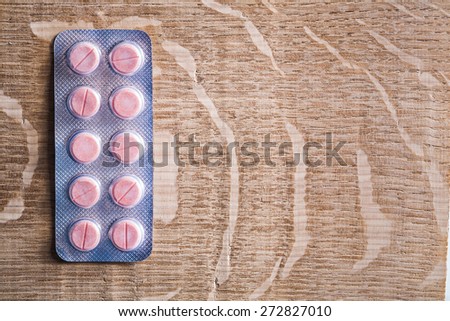 blister pack with rose medical pils on wooden board with cpyspace