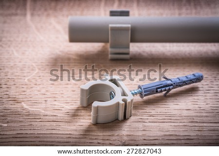 Close Up  Pipe With Clips And Polypropylene Fixator On Wooden Board