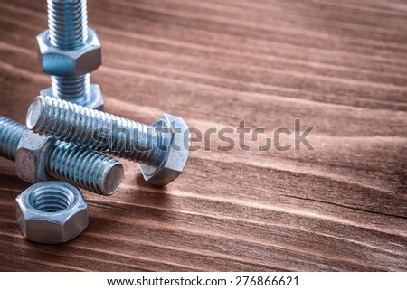 Collection of metal bolts and screw nuts on vintage wooden board construction concept