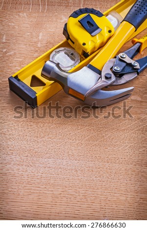Claw hammer construction level nippers and tape measure on wooden background