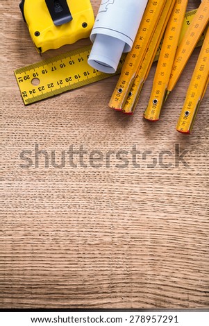 Construction plans and yellow instruments of measurement on oaken wooden board maintenance concept