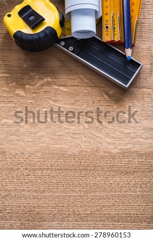 Blueprints square ruler tape measure pencil and wooden meter on oak board construction concept
