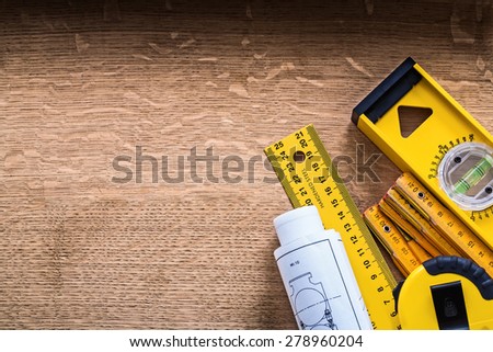 Blueprints and set of instruments of measurement on oak wood board construction concept