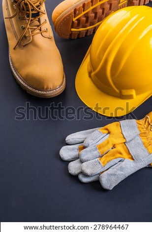 protective working wear construction helmet work gloves working boots on black background