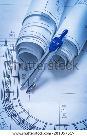 Rolls of blueprints and drawing compass construction concept