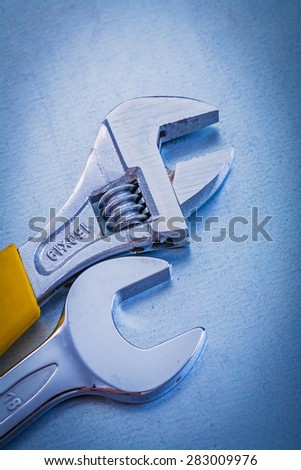 Metallic background with stainless adjustable spanner and hook wrench repairing concept