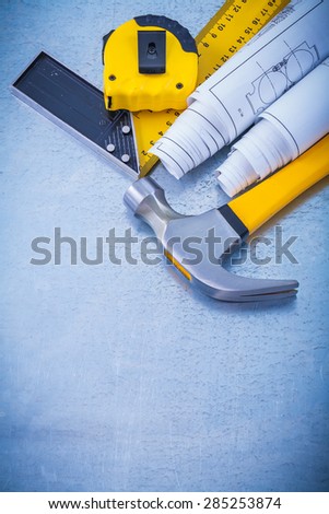 Metallic background with blueprints claw hammer square ruler and measuring line maintenance concept