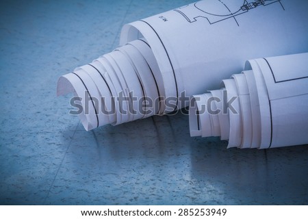 Rolls of blueprints on metallic background building and architecture concept