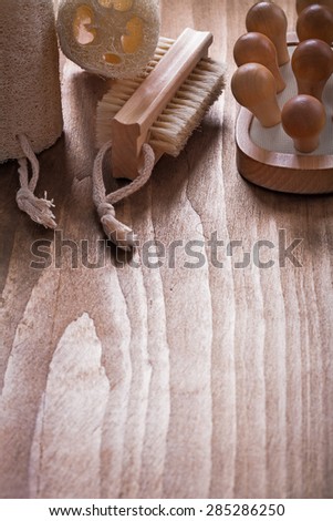 Vertical image of bath brush loofahs and back massager on pine vintage wood board healthcare concept
