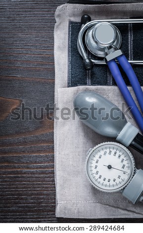 Close up image of stethoscope and blood pressure monitor on vintage wooden background medicine concept