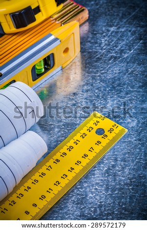 Construction level blueprints and units of measurement on metallic scratched background building and architecture concept.
