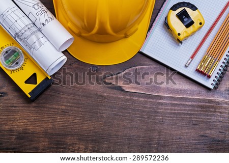Checked notepad pencil and construction objects on pine wood board maintenance concept