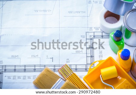 Duct tape wooden meter and paint tools on construction drawing vertical image maintenance concept.
