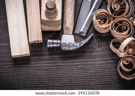 Vertical view of planer hammer chisels wooden studs and curled shavings on vintage wood board construction concept.