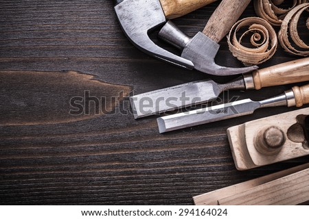 Horizontal version of planer hammer metal chisels wooden studs and curled shavings on vintage wood board construction concept.