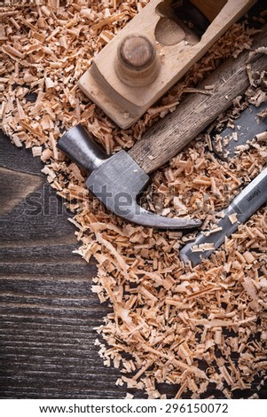 Vintage wood board with claw hammer chisels wooden planer and shavings construction concept.