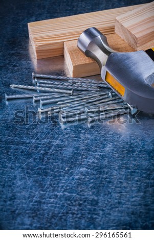 Metal nails claw hammer and wooden studs on scratched metallic background copy space image construction concept.