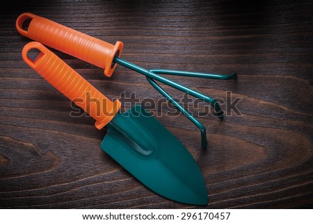 Hand gardening spade with trowel fork on vintage wood board agriculture concept.