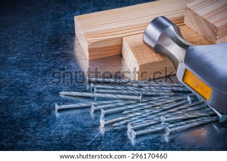 Construction nails claw hammer and wooden studs on scratched metallic background maintenance concept.