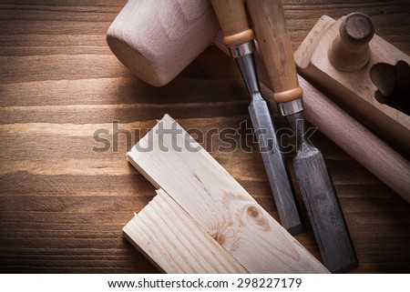 Wooden mallet planner chisels building planks on wood board construction concept.