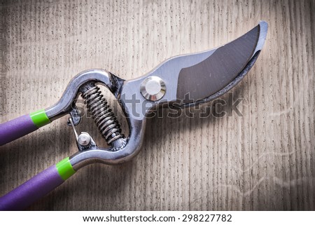 Sharp metal pruning shears on wooden board agriculture concept.