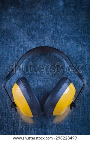 Noise insulation ear muffs on metallic surface construction concept.