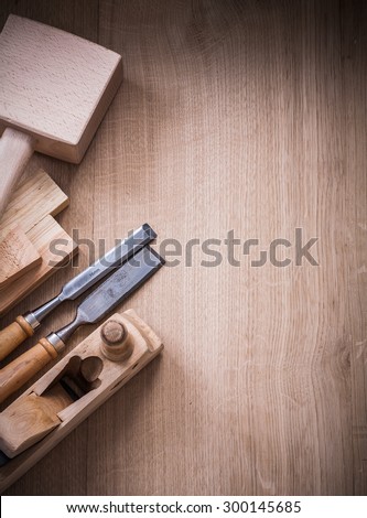Vertical view of lump hammer shaving plane metal chisels and wooden planks on wood board construction concept.