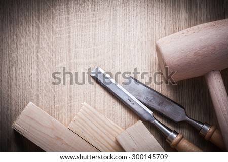 Wooden bricks mallets flat chisels on wood background close up view construction concept.