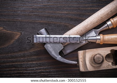 Set of claw hammer planer and firmer chisels on vintage wooden board construction concept.