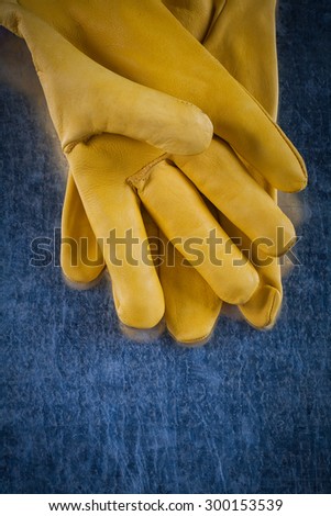 Leather protective gloves on scratched metallic background construction concept.