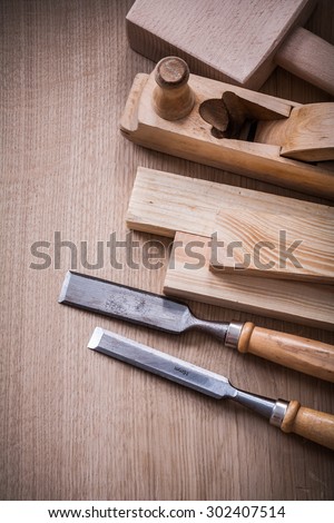 Hand mallet shaving plane metal chisels and wooden stud on brown board construction concept.