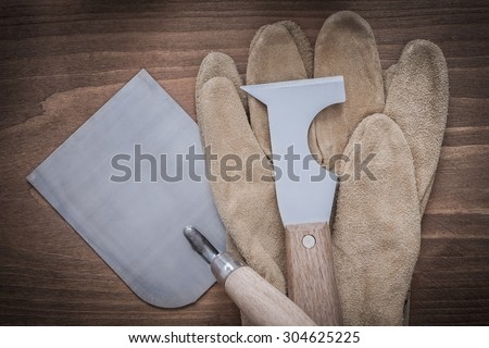 Sharp construction spatula bricklaying trowel and leather protective gloves.
