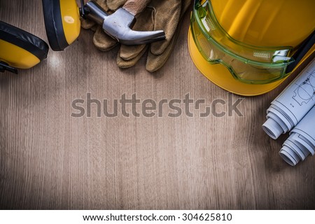 Hammer safety glasses construction plans protective gloves hard hat earmuffs.