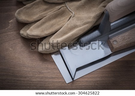 Palette knife plastering trowel and leather safety gloves horizontal view.