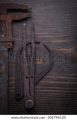 Collection of rusty vernier scales on vintage wooden board.